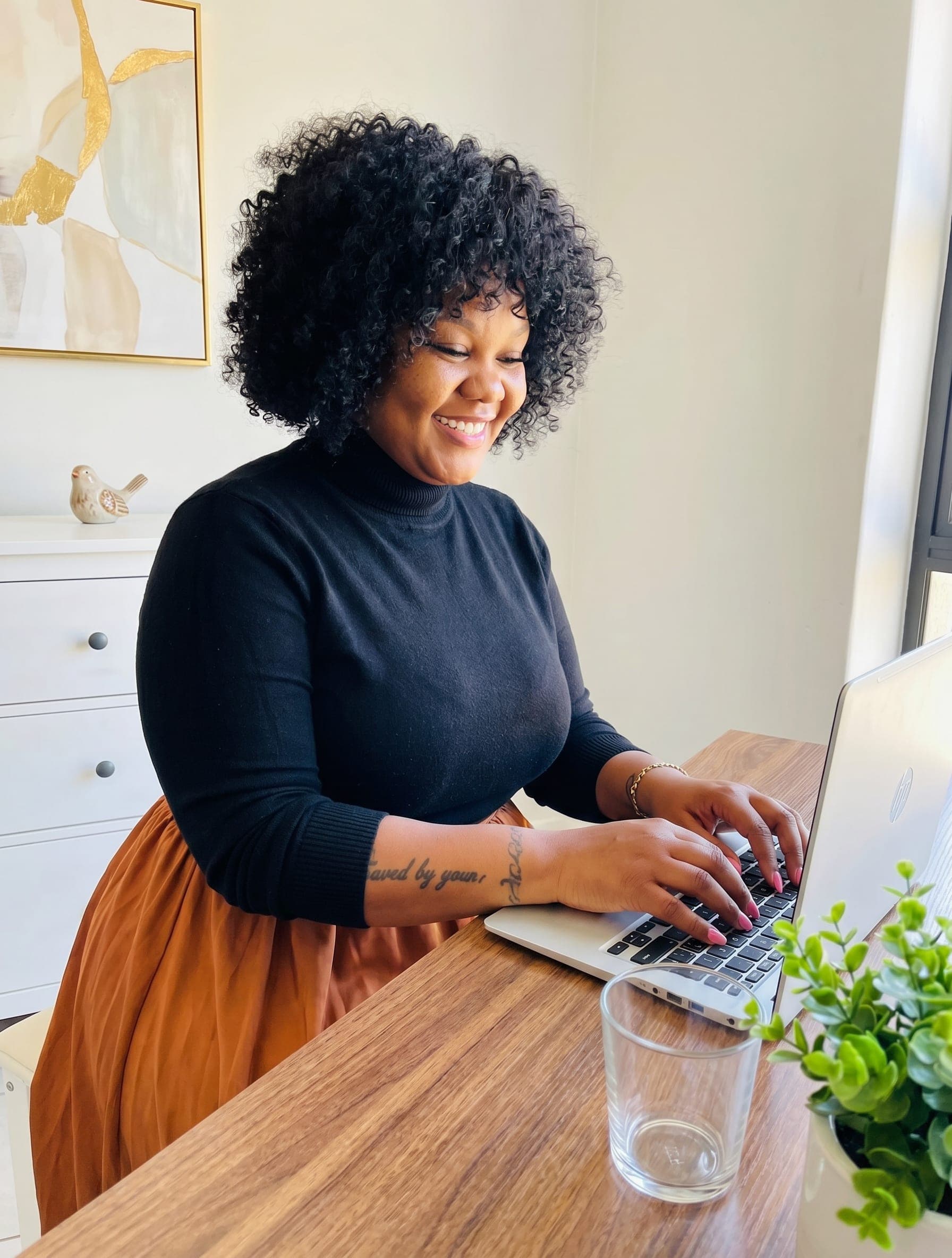 Coach Kagiso working at a laptop in a bright home office
